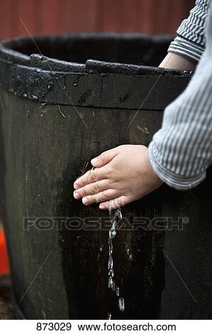 A person stopping water leaking from a wooden barrel View Large Photo Image Stock Photo - A person stopping water leaking from a wooden barrel. Fotosearch