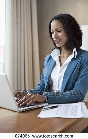 A businesswoman working at a desk View Large Photo Image Stock Photography - A businesswoman working at a desk. Fotosearch