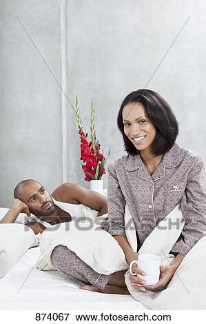 Stock Photo - A couple relaxing in bed, portrait. Fotosearch