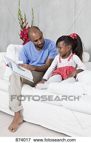 Stock Photo - A father reading with his young daughter. Fotosearch