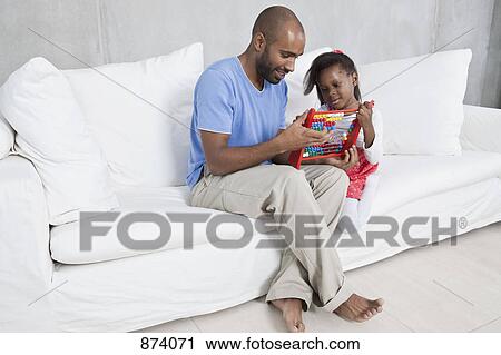 A father showing his young daughter how to use an abacus View Large Photo Image Stock Image - A father showing his young daughter how to use an abacus. Fotosearch