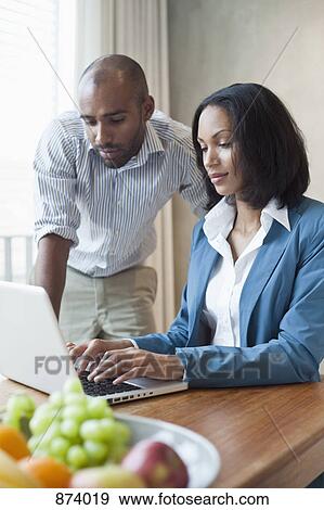 Stock Photo - A man and a woman working together. Fotosearch