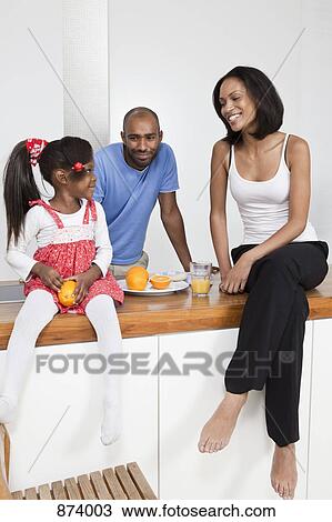 Stock Image - A young family relaxing. Fotosearch