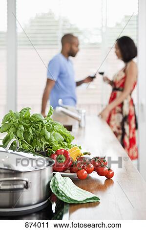 Fresh produce on a kitchen counter and a young couple in background View Large Photo Image Stock Image - Fresh produce on a kitchen counter and a young couple in background. Fotosearch