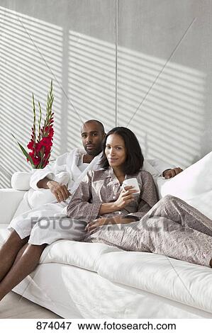 Portrait of a young couple on a sofa View Large Photo Image Stock Photo - Portrait of a young couple on a sofa. Fotosearch