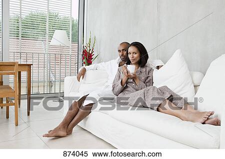 Portrait of a young couple on a sofa View Large Photo Image Stock Photography - Portrait of a young couple on a sofa. Fotosearch