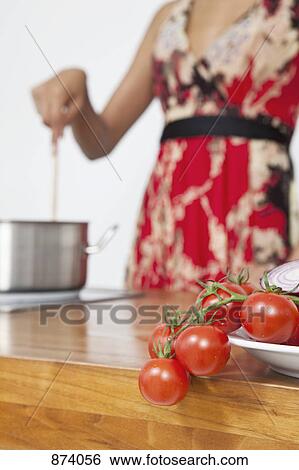 Tomatoes, mid section of woman in background View Large Photo Image Stock Photograph - Tomatoes, mid section of woman in background. Fotosearch
