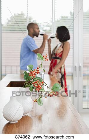 Two vases, one with a branch of Hypericum berries in it, young couple in background View Large Photo Image Stock Image - Two vases, one with a branch of Hypericum berries in it, young couple in background. Fotosearch