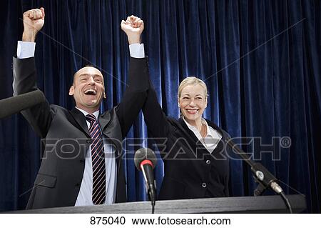 A man and a woman cheering at a lectern View Large Photo Image Stock Image - A man and a woman cheering at a lectern. Fotosearch