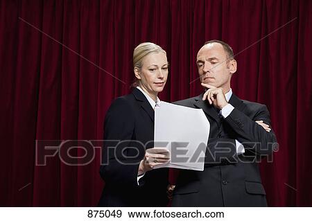Stock Photo - A man and a woman looking at a document together. Fotosearch