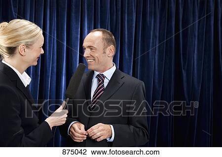 A man in a suit being interviewed by a woman View Large Photo Image Stock Image - A man in a suit being interviewed by a woman. Fotosearch