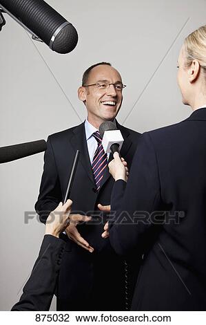 A man in a suit being interviewed by the media View Large Photo Image Stock Image - A man in a suit being interviewed by the media. Fotosearch