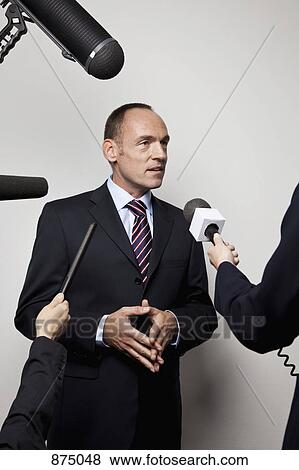 A man in a suit being interviewed by the media View Large Photo Image Stock Photo - A man in a suit being interviewed by the media. Fotosearch