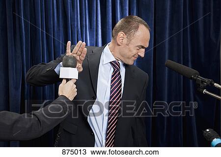 A man in a suit refusing to be interviewed View Large Photo Image Stock Image - A man in a suit refusing to be interviewed. Fotosearch