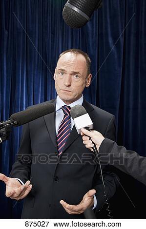 A man in a suit shrugging during an interview View Large Photo Image Stock Photo - A man in a suit shrugging during an interview. Fotosearch