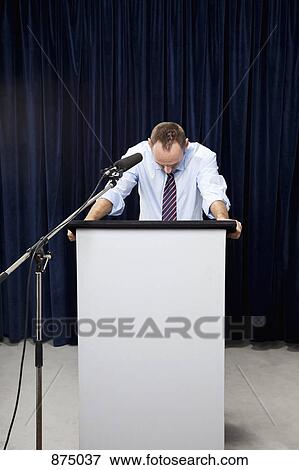 A man looking down behind a lectern View Large Photo Image Stock Photo - A man looking down behind a lectern. Fotosearch