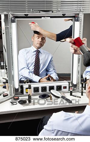 Stock Image - A mature man having make-up done. Fotosearch