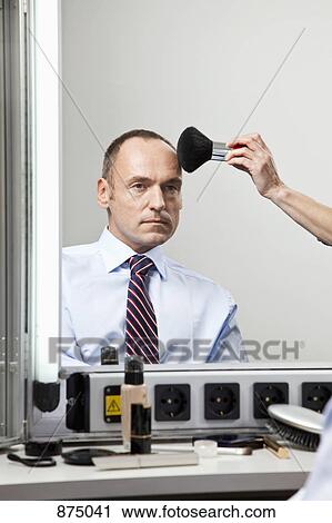 Stock Image - A mature man having make-up done. Fotosearch