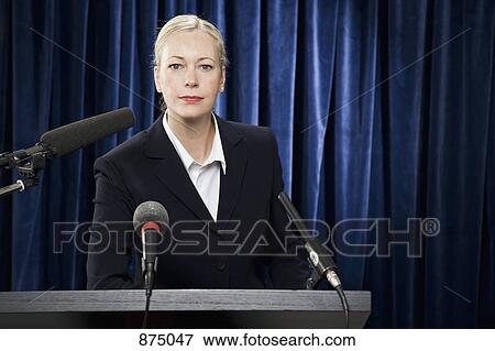 A woman in a suit at a lectern View Large Photo Image Stock Photo - A woman in a suit at a lectern. Fotosearch