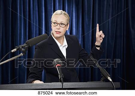 A woman in a suit speaking at a lectern View Large Photo Image Picture - A woman in a suit speaking at a lectern. Fotosearch