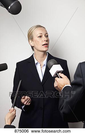 A woman in a suit talking to the media View Large Photo Image Stock Photograph - A woman in a suit talking to the media. Fotosearch