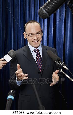 Portrait of a man in a suit being interviewed by the media View Large Photo Image Stock Photo - Portrait of a man in a suit being interviewed by the media. Fotosearch