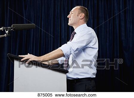 Side view of a man standing at a lectern View Large Photo Image Stock Photography - Side view of a man standing at a lectern. Fotosearch