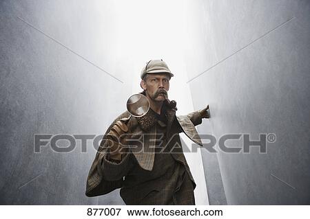 A man dressed like Sherlock Holmes holding a magnifying glass View Large Photo Image Stock Photo - A man dressed like Sherlock Holmes holding a magnifying glass. Fotosearch