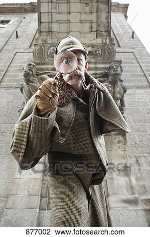 A man dressed up as Sherlock Holmes with a magnifying glass distorting his eye View Large Photo Image Stock Image - A man dressed up as Sherlock Holmes with a magnifying glass distorting his eye. Fotosearch
