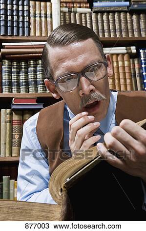 A man looking shocked while reading a book in a bookstore View Large Photo Image Stock Image - A man looking shocked while reading a book in a bookstore. Fotosearch