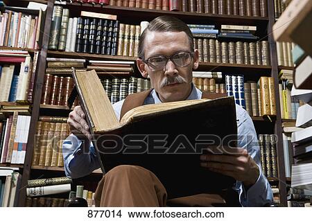 A man reading a book in a bookstore View Large Photo Image Picture - A man reading a book in a bookstore. Fotosearch