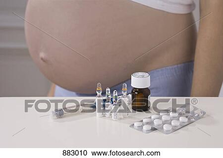 A pregnant woman, midsection, with prenatal medicine, focus on medicine View Large Photo Image Stock Image - A pregnant woman, midsection, with prenatal medicine, focus on medicine. Fotosearch