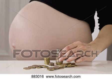 A pregnant woman stacking EU coins, midsection, focus on hand View Large Photo Image Stock Photograph - A pregnant woman stacking EU coins, midsection, focus on hand. Fotosearch