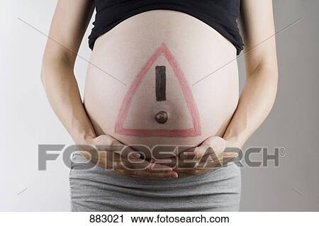 A warning sign drawn on a pregnant belly, midsection, focus on abdomen View Large Photo Image Stock Image - A warning sign drawn on a pregnant belly, midsection, focus on abdomen. Fotosearch