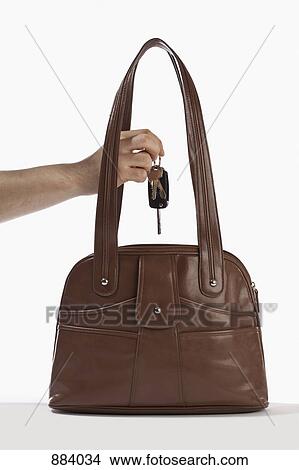 Detail of a man taking keys out of a handbag View Large Photo Image Picture - Detail of a man taking keys out of a handbag. Fotosearch