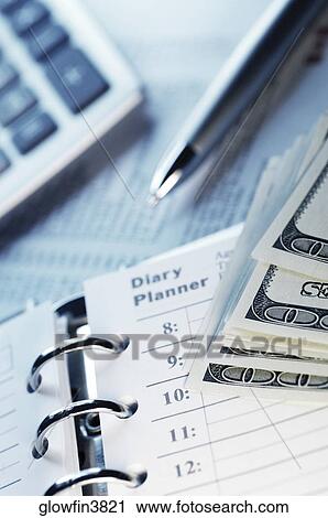 Stock Image - Appointment book, calculator, pen and US one hundred dollar bills, close-up. Fotosearch