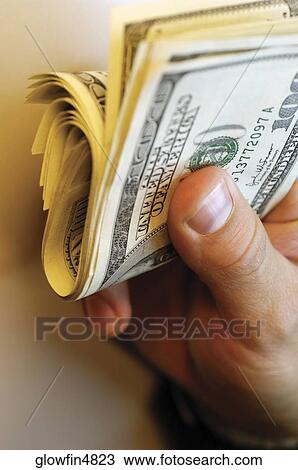 Businessman holding bankroll of United States currency, close-up View Large Photo Image Stock Image - Businessman holding bankroll of United States currency, close-up. Fotosearch
