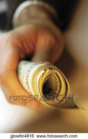 Businessman holding bankroll of United States currency, close-up View Large Photo Image Stock Photograph - Businessman holding bankroll of United States currency, close-up. Fotosearch