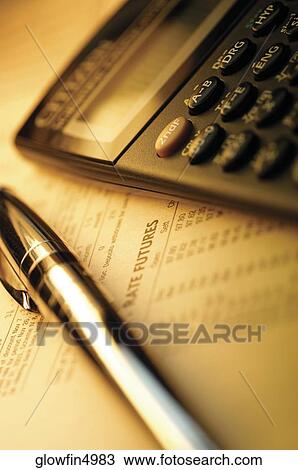 Stock Image - Calculator and pen on top of list of financial data, close-up. Fotosearch