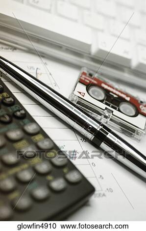 Calculator, computer keyboard, micro cassette recording tape and pen on top of financial graph, close-up View Large Photo Image Stock Image - Calculator, computer keyboard, micro cassette recording tape and pen on top of financial graph, close-up. Fotosearch