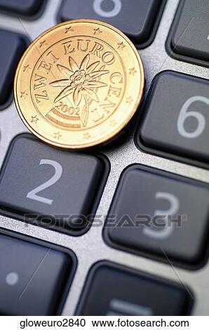 Stock Image - Close-up of Eurocent coin on calculator. Fotosearch