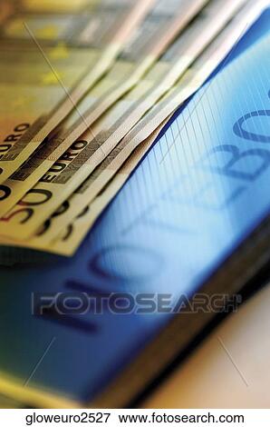 Stock Photo - Close-up of fifty Euro banknotes on a notebook. Fotosearch