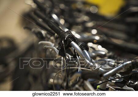 Close-up of the handlebars of parked cycles View Large Photo Image Stock Image - Close-up of the handlebars of parked cycles. Fotosearch