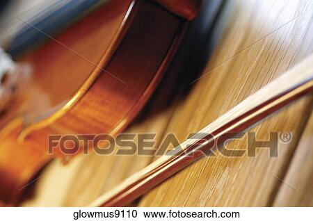 Close-up of violin and violin bow on wooden table View Large Photo Image Stock Image - Close-up of violin and violin bow on wooden table. Fotosearch