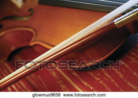 Close-up of violin and violin bow on wooden table View Large Photo Image Stock Photo - Close-up of violin and violin bow on wooden table. Fotosearch