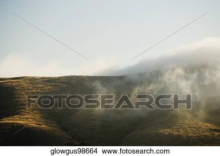 Clouds rolling over a hill range View Large Photo Image Picture - Clouds rolling over a hill range. Fotosearch
