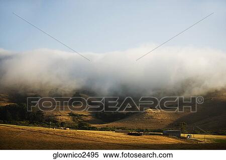 Clouds rolling over a hill range View Large Photo Image Stock Photography - Clouds rolling over a hill range. Fotosearch