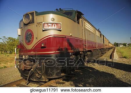 Commuter train moving on railroad track View Large Photo Image Stock Image - Commuter train moving on railroad track. Fotosearch