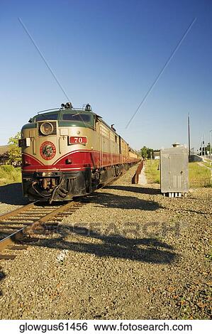 Commuter train moving on railroad track View Large Photo Image Stock Photograph - Commuter train moving on railroad track. Fotosearch
