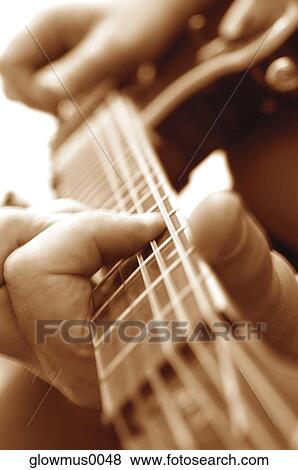 Extreme close-up of man playing guitar View Large Photo Image Stock Photo - Extreme close-up of man playing guitar. Fotosearch